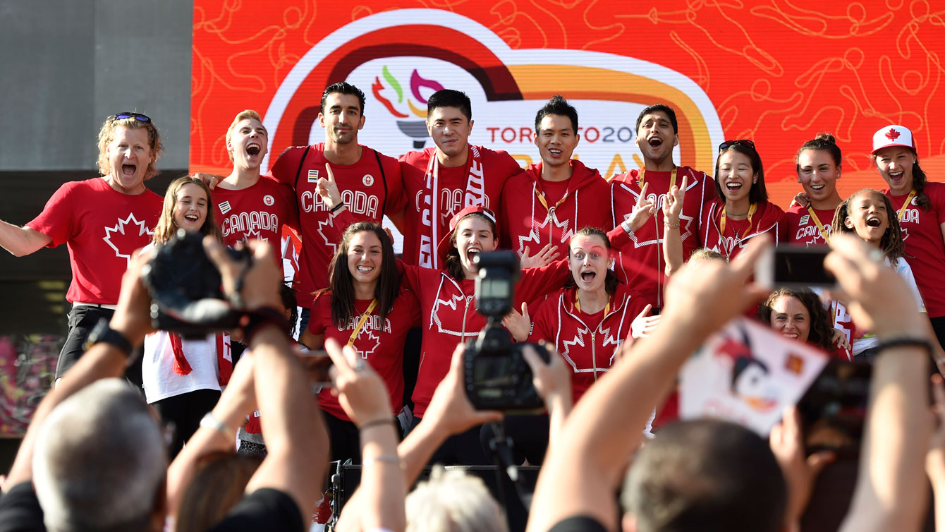 Team Canada chef de mission Curt Harnett (left, with the hair) leads athletes to the stage at Nathan Phillips Square on July 9, 2015 (Jason Ransom/COC).