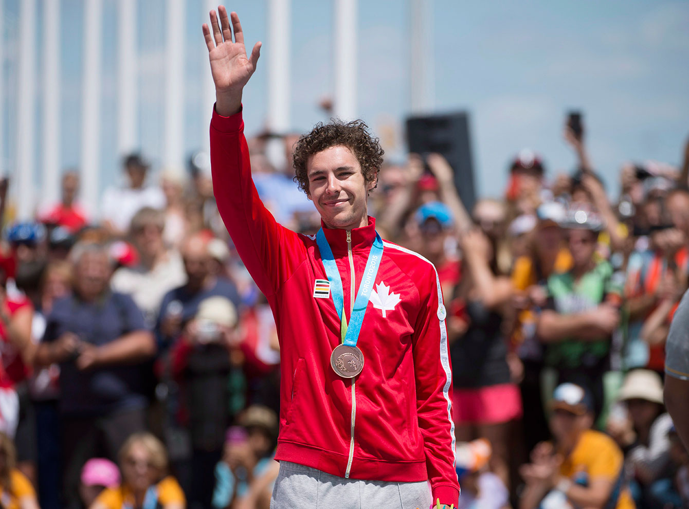 Sean MacKinnon waves during the medal ceremony for the men's individual time trial at TO2015.
