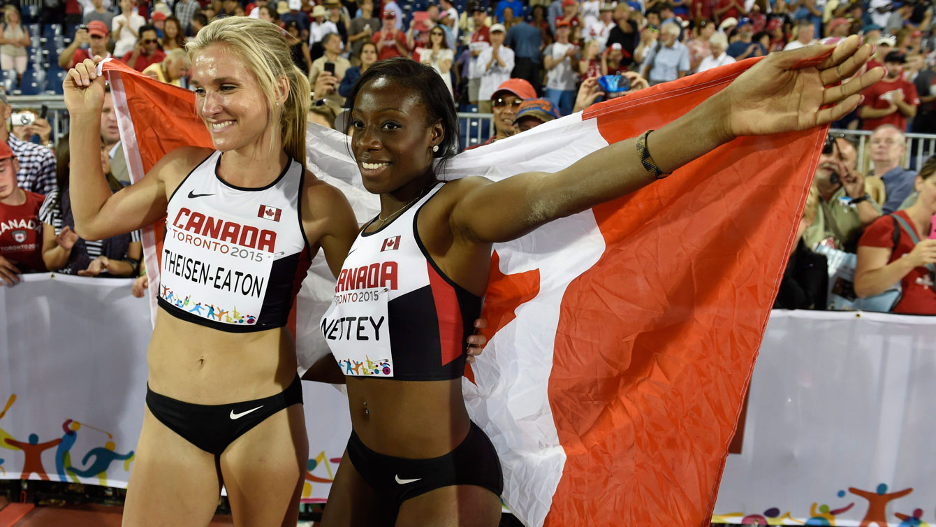 Christabel Nettey and Brianne Theisen-Eaton gather in front of the Canadian flag at the Pan Am Games on July 24, 2015 in Toronto.