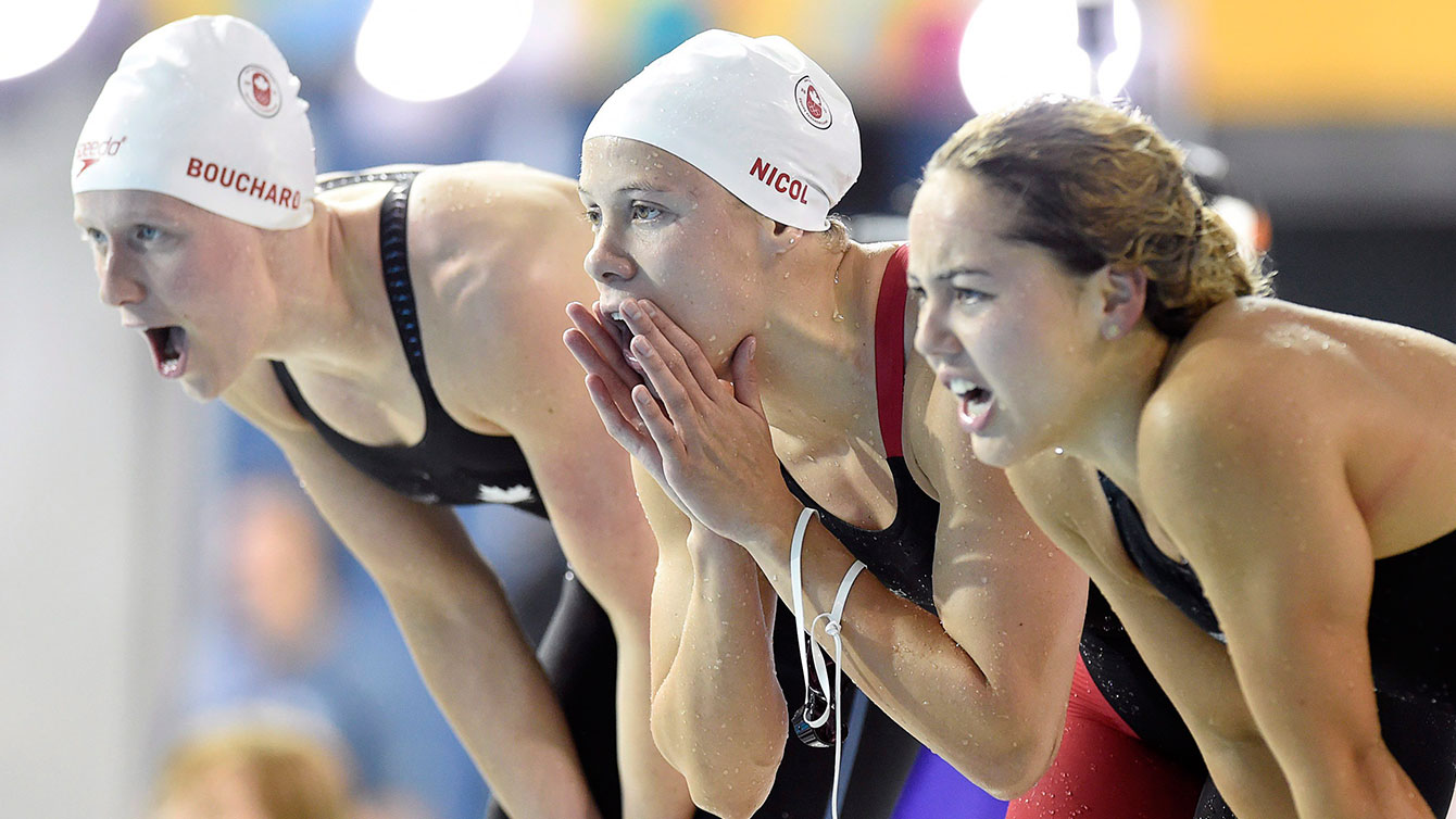From left Dominique Bouchard, Rachel Nicol, and Noemie Thomas cheer on the women's 4x100m medley relay.