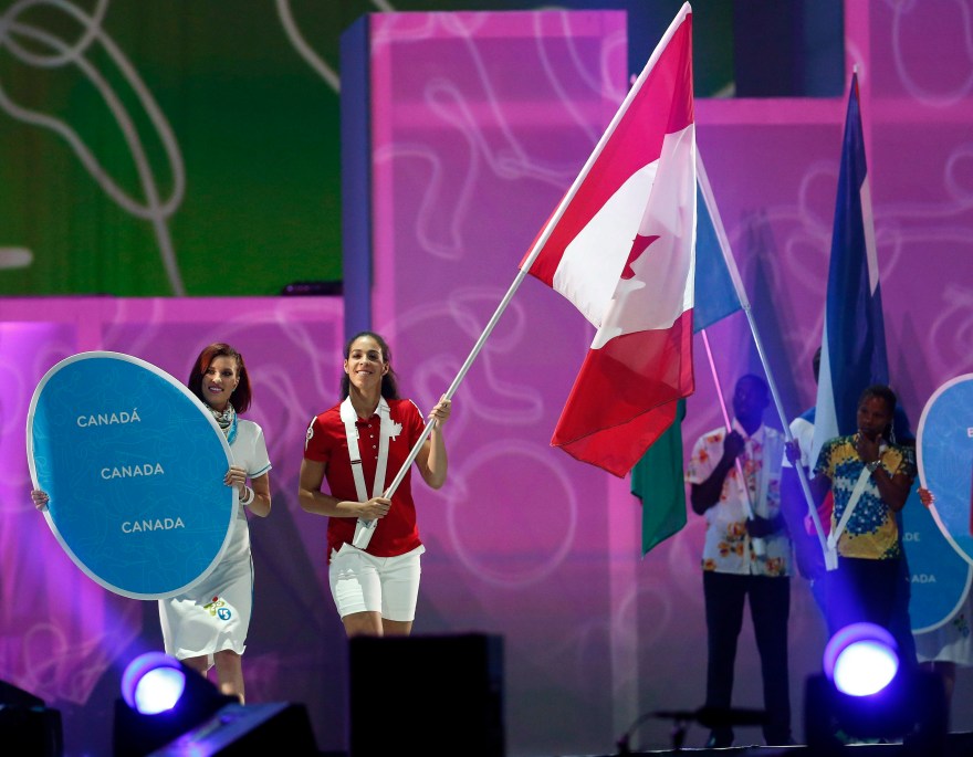 Basketball player Kia Nurse carries in the Canadian flag during the parade of nations at the closing ceremony