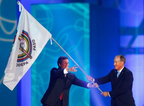 Toronto Mayor John Tory, left, passes the Pan American Sports Organization flag