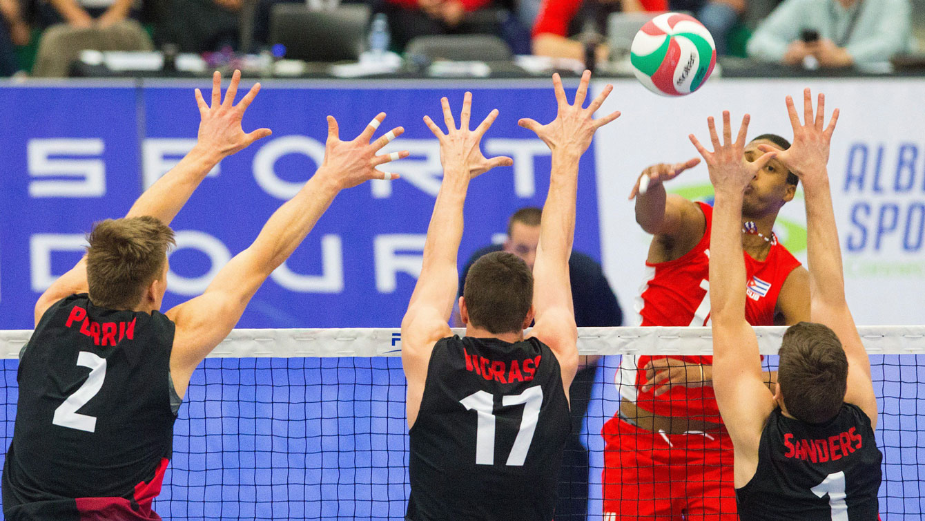Cuba's Osmany Santiago Uriarte Mestre hits the ball against Canada during a decisive NORCECA Olympic qualifying match on January 10, 2016. 