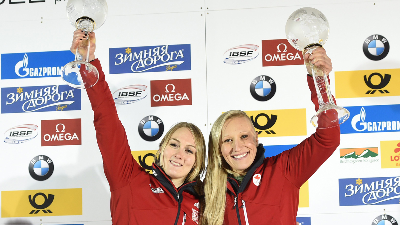 Kaillie Humphries and Melissa Lotholz holding up their trophies for the overall World Cup victory at Lake Koenigssee Germany February 26, 2016.