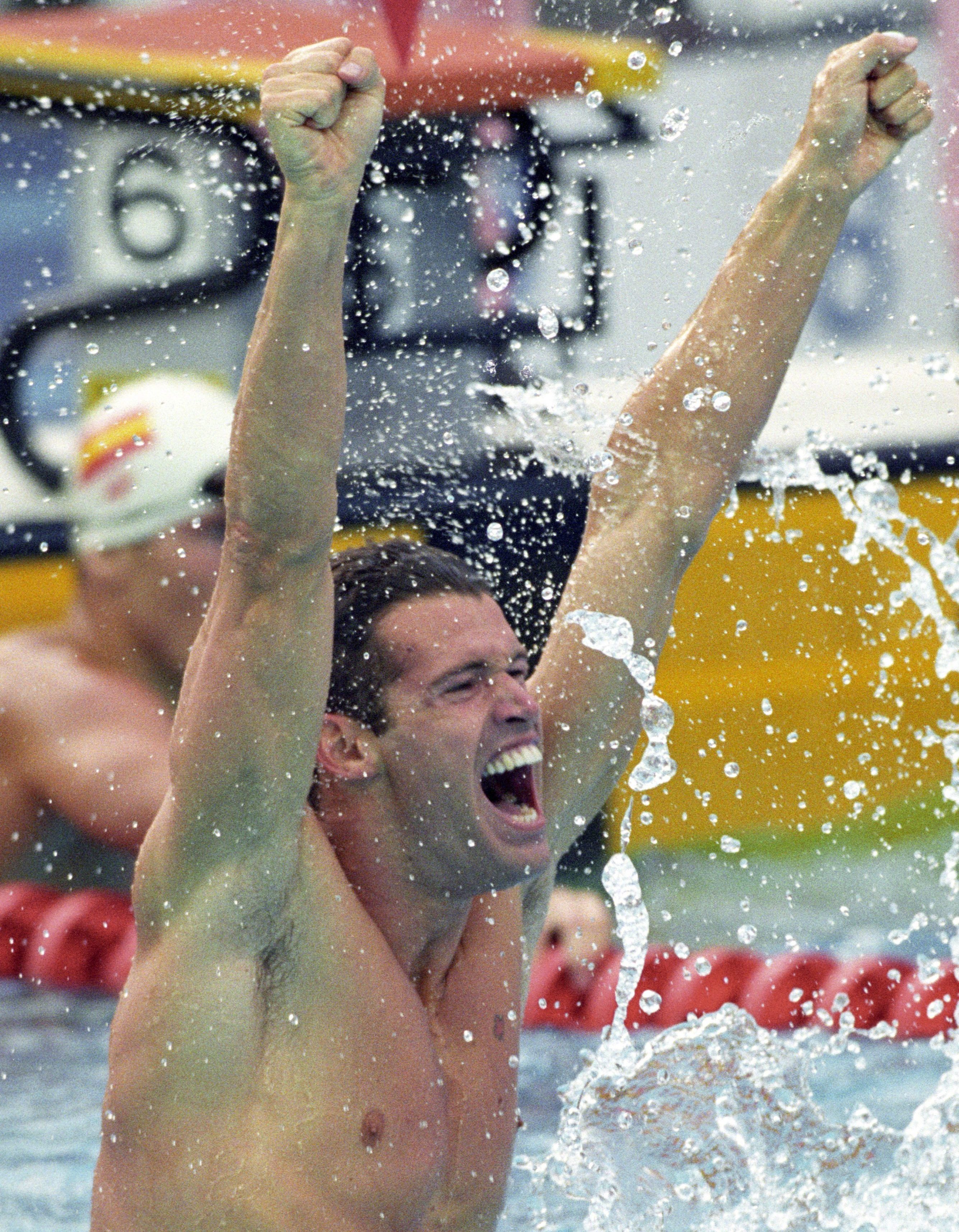 Swimmer sitting on lane rope cheering