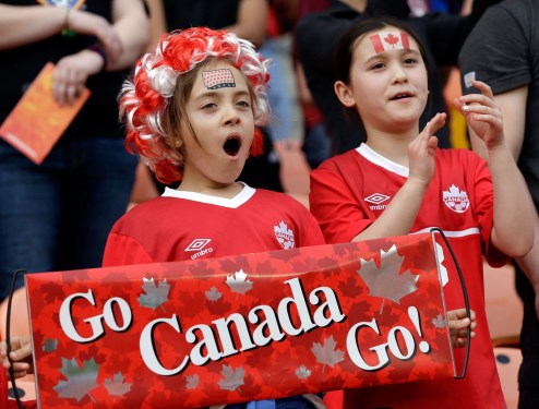 Two young Team Canada fans cheer for Canada's women's soccer team as they take the field for a CONCACAF Olympic qualifying tournament soccer match against. (AP Photo/David J. Phillip)
