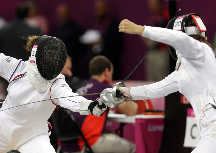 France's Elodie Clouvel, left, battles against Canada's Melanie McCann, right, during the fencing portion of the women's modern pentathlon competition at the 2012 Summer Olympics Sunday, Aug. 12, 2012, in London. (AP Photo/Hussein Malla)
