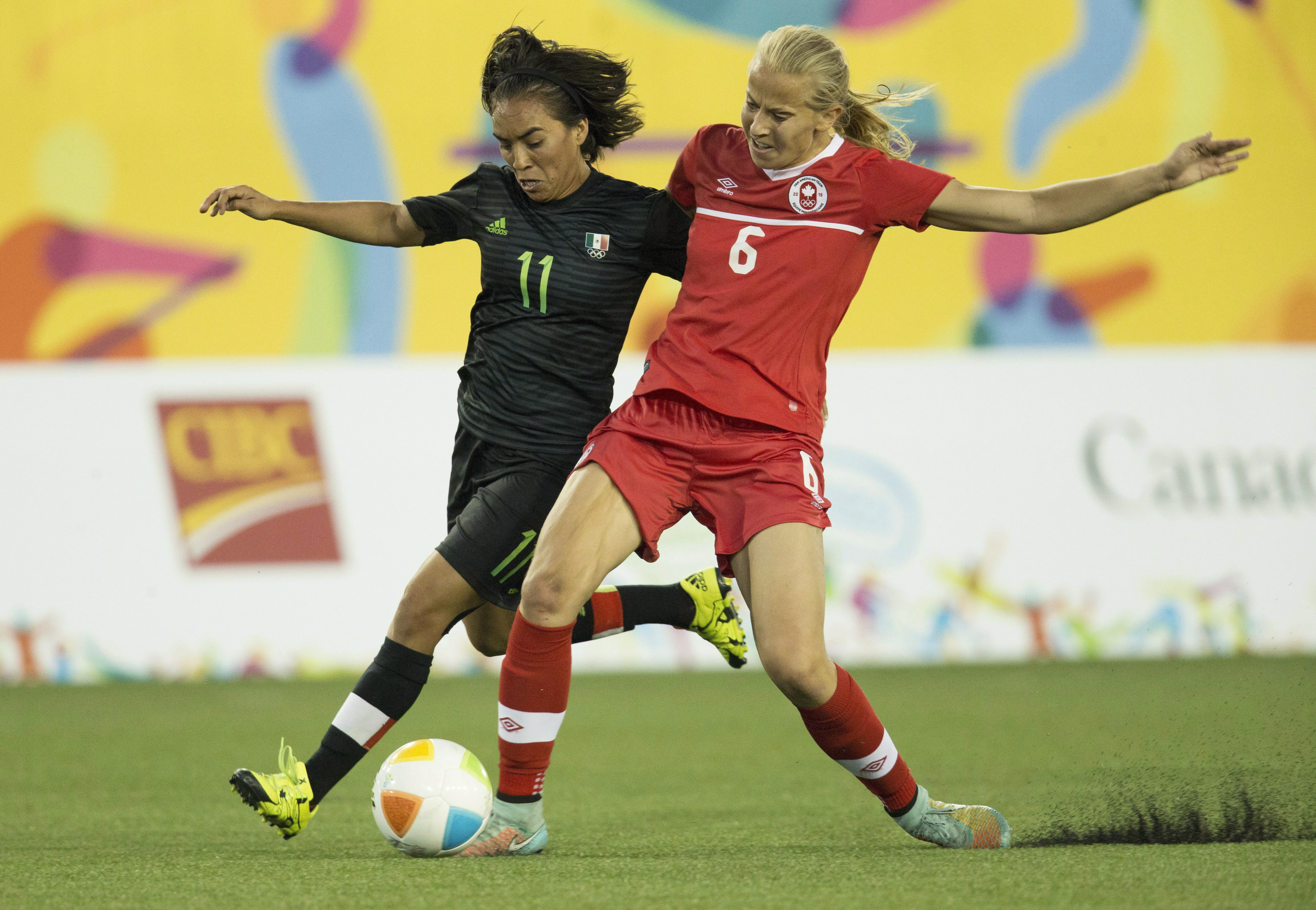 Canada's Rebecca Quinn (6) and Mexico's Monica Ocampo (11) fight for ball posession during the first half of the 2015 Pan Am Games women's bronze medal soccer match in Hamilton, Ontario on Friday, July 24, 2015. THE CANADIAN PRESS/Peter Power