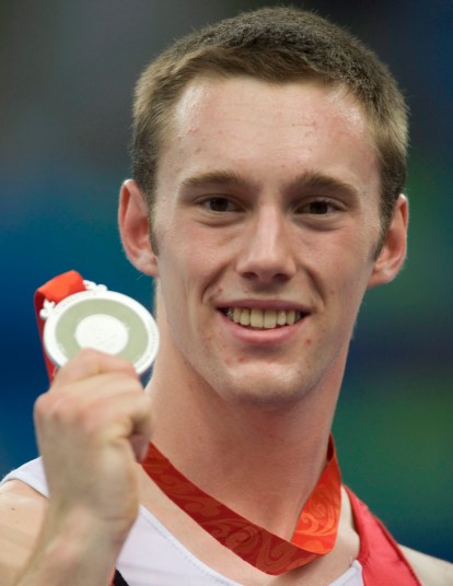 Canada's Jason Burnett, from Etobicoke, Ont. holds up his silver medal following competition in the mens trampoline final at the the Beijing Olympics in Beijing, China Tuesday, Aug.19, 2008. THE CANADIAN PRESS/Adrian Wyld