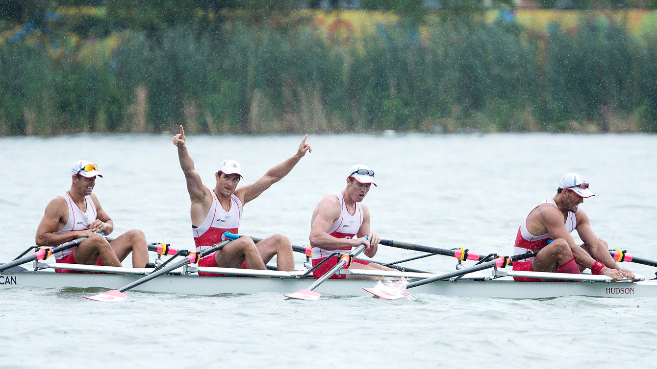 From left to right, Matthew Buie, Julien Bahain, with arms raised, Dean Will, and Rob Gibson coast in their boat after winning gold in the men's quadruple sculls at the 2015 Pan Am Games at the Royal Canadian Henley Rowing Course in St. Catharines, Ontario on Tuesday, July 14, 2015. (THE CANADIAN PRESS/Peter Power)