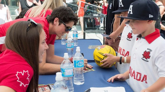 Britt Benn and Natasha Watcham-Roy signing autographs for fans after the Team Canada Rugby send-off on July 26, 2016. (Tavia Bakowski/COC)