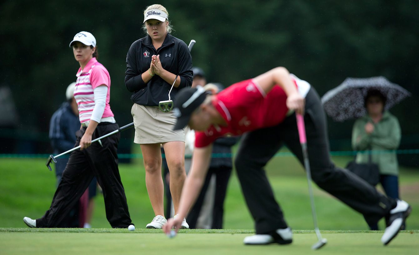 Fourteen-year-old Brooke Henderson, second left, of Smiths Falls, Ont., waits to putt on the 17th hole as Alena Sharp, right, of Hamilton, Ont., places her ball and Mo Martin, left, of Altadena, Calif., looks on during the first round of the CN Canadian Women's Open LPGA golf tournament at the Vancouver Golf Club in Coquitlam, B.C., on Thursday August 23, 2012. THE CANADIAN PRESS/Darryl Dyck