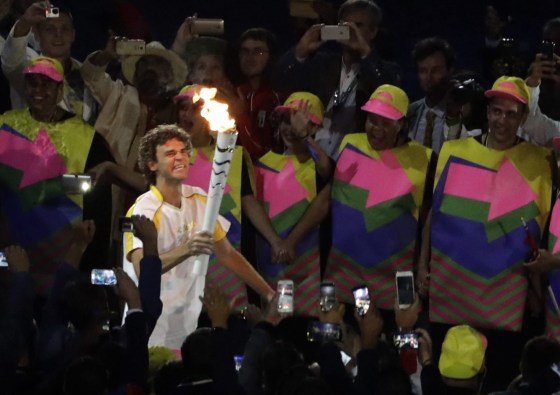 Former Brazilian tennis player Gustavo Kuerten arrives with the Olympic flame during the opening ceremony for the 2016 Summer Olympics in Rio de Janeiro, Brazil, Friday, Aug. 5, 2016. (AP Photo/Jae C. Hong)