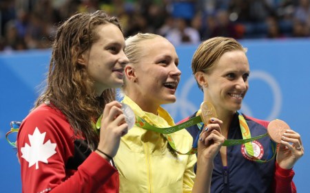 Winner Sweden's Sarah Sjostrom, center, second placed Canada's Penny Oleksiak, left, and third placed United States' Dana Vollmer hold their medals after the women's 100-meter butterfly during the swimming competitions at the 2016 Summer Olympics, Sunday, Aug. 7, 2016, in Rio de Janeiro, Brazil. (AP Photo/Lee Jin-man)