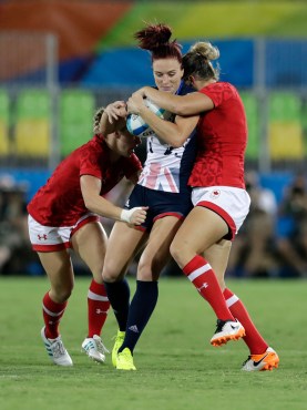 Great Britain's Joanne Watmore, middle, is tackled by Canada's Kayla Moleschi, left, and teammate Kelly Russell, during the women's rugby sevens bronze medal match at the Summer Olympics in Rio de Janeiro, Brazil, Monday, Aug. 8, 2016. (AP Photo/Themba Hadebe)
