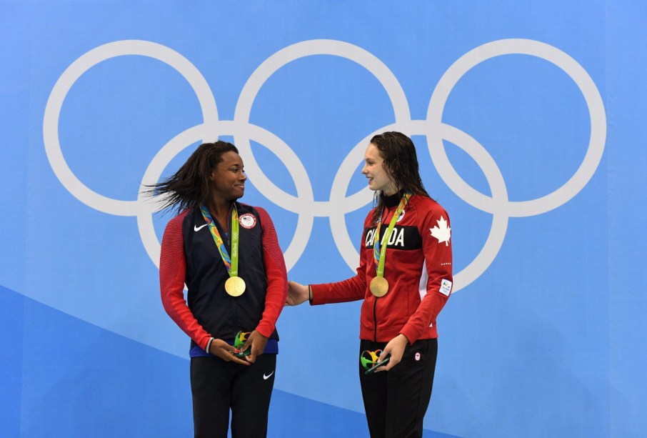 Canada's Penny Oleksiak and the United States' Simone Manuel celebrate their tie for gold in the women's 100m freestyle finals during the 2016 Olympic Summer Games in Rio de Janeiro, Brazil, on Friday, Aug. 12, 2016. THE CANADIAN PRESS/Sean Kilpatrick