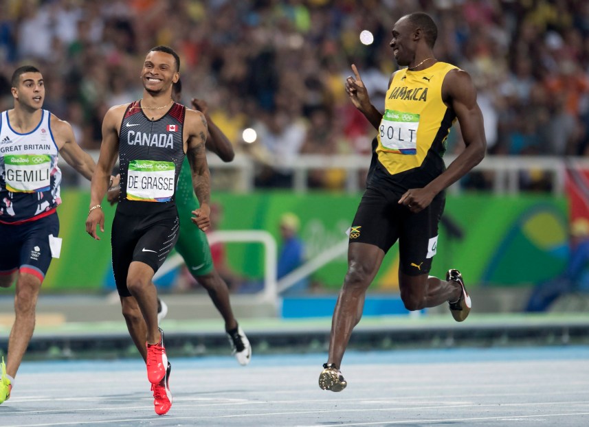 Bolt and De Grasse smiling as they cross the finish line