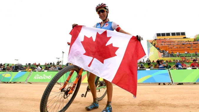 Canada's Catharine Pendrel poses with the Canadian flag as she celebrates winning the bronze medal in the women's mountain bike final at the 2016 Olympic Summer Games in Rio de Janeiro, Brazil on Saturday, Aug. 20, 2016. THE CANADIAN PRESS/Sean Kilpatrick