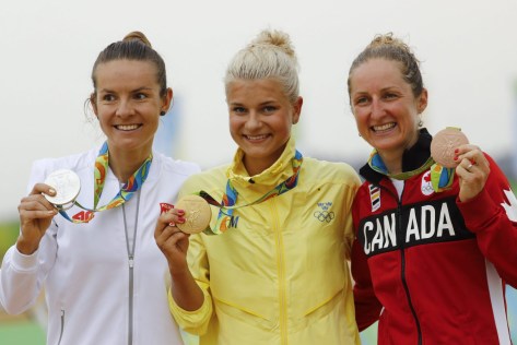 Gold medalist Jenny Rissveds of Sweden, center, silver medalist Maja Wloszczowska of Poland, left, and bronze medalist Catharine Pendrel of Canada, right, stand on the podium of the women's cross-country mountain bike race at the 2016 Summer Olympics in Rio de Janeiro, Brazil, Saturday, Aug. 20, 2016. (AP Photo/Patrick Semansky)
