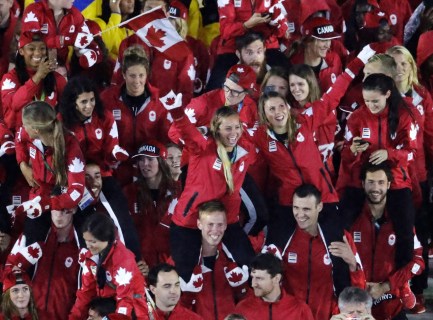 Athetes from Canada, some wearing mittens, march into the closing ceremony in the Maracana stadium at the 2016 Summer Olympics in Rio de Janeiro, Brazil, Sunday, Aug. 21, 2016. (AP Photo/Charlie Riedel)