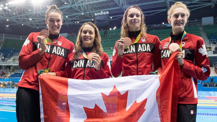 (L-R), Chantal Van Landeghem, Sandrine Mainville, Penny Oleksiak and Taylor Ruck celebrate their Olympic bronze medal in women's 4x100m freestyle relay on August 6, 2016.