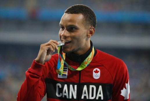 Rio 2016: Andre De Grasse Andre De Grase bites his silver medal on the podium