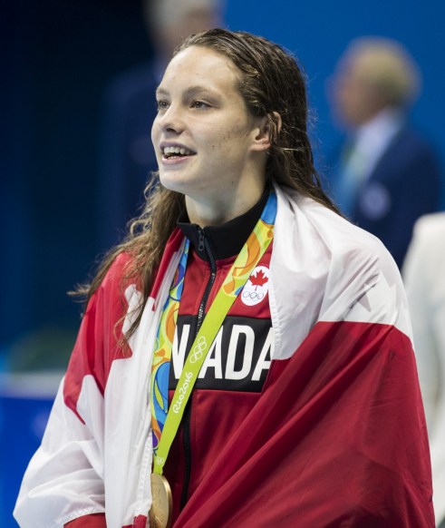 Rio 2016: Penny Oleksiak 100m freestyle Canada's Penny Oleksiak with her flag and gold medal after finishing first in the women's 100-meter freestyle during the swimming competitions at the 2016 Summer Olympics, Thursday, Aug. 11, 2016, in Rio de Janeiro, Brazil. (COC photo/Stephen Hosier)