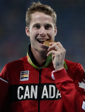 Rio 2016: Derek Drouin Derek Drouin bites his high jump gold medal at Rio 2016. August 17, 2016. COC Photo/Jason Ransom.