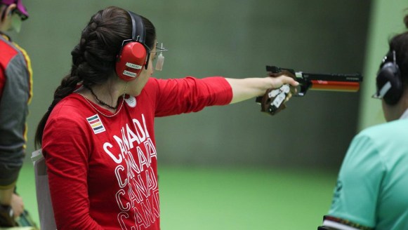 Lynda Kiejko holds her pistol at arms length to shoot