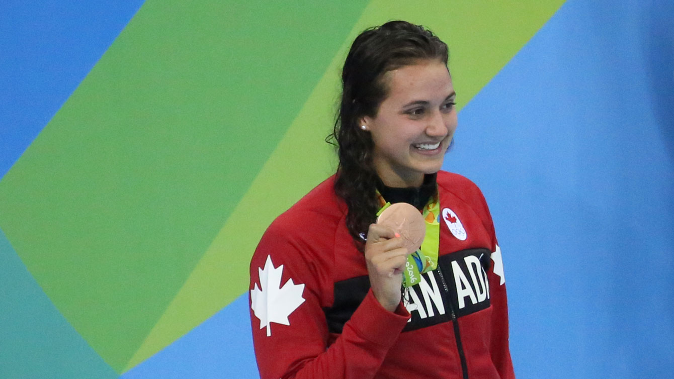 Kylie Masse holds up her Olympic bronze medal at Rio 2016 after the 100m backstroke on August 8, 2016.