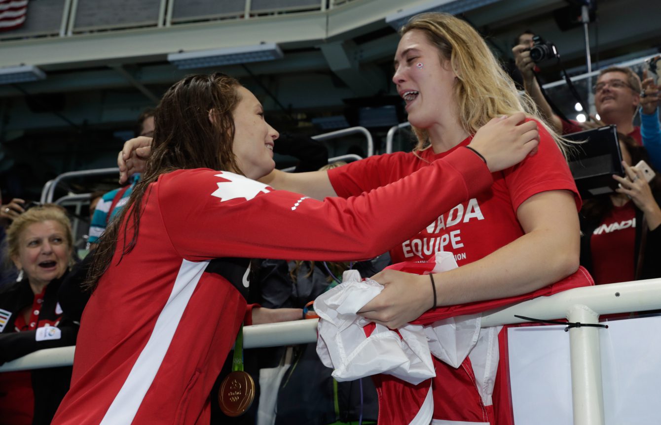 Penny Oleksiak embraces a family member after winning the gold medal and setting a new olympic record in the women's 100-meter freestyle during the swimming competitions at the 2016 Summer Olympics, Thursday, Aug. 11, 2016, in Rio de Janeiro, Brazil. (COC photo/JasonRansom)