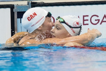 Canada's Penny Oleksiak, right, gets a hug from teammate Chantal Van Landeghem after Oleksiak qualified for the women's 100m freestyle final at the Olympic games in Rio de Janeiro, Brazil, Wednesday, August 10, 2016. COC Photo by Jason Ransom