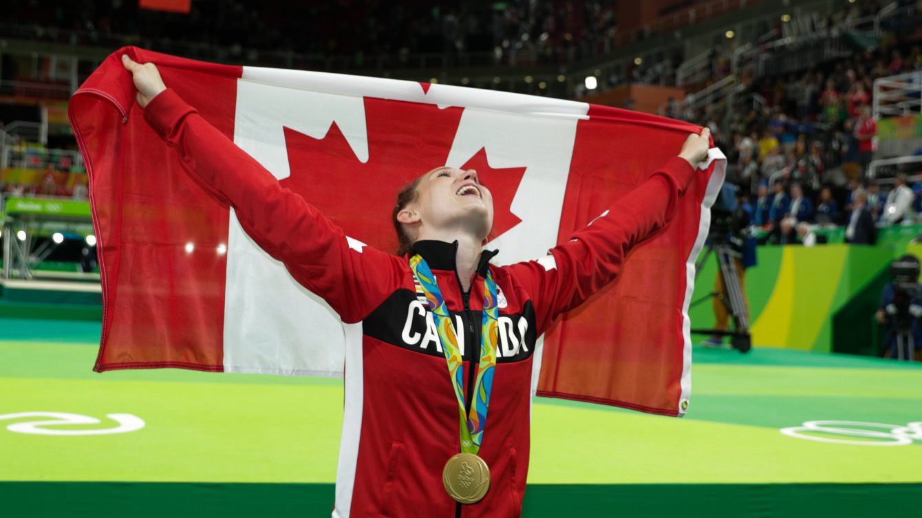 Rosie MacLennan pictured with the Canadian flag after successfully defending her trampoline gold at the Rio 2016 Olympic Games. (COC photo/Jason Ransom)