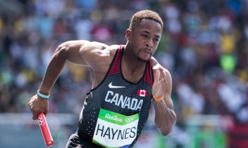 Akeem Haynes sprinting while holding baton