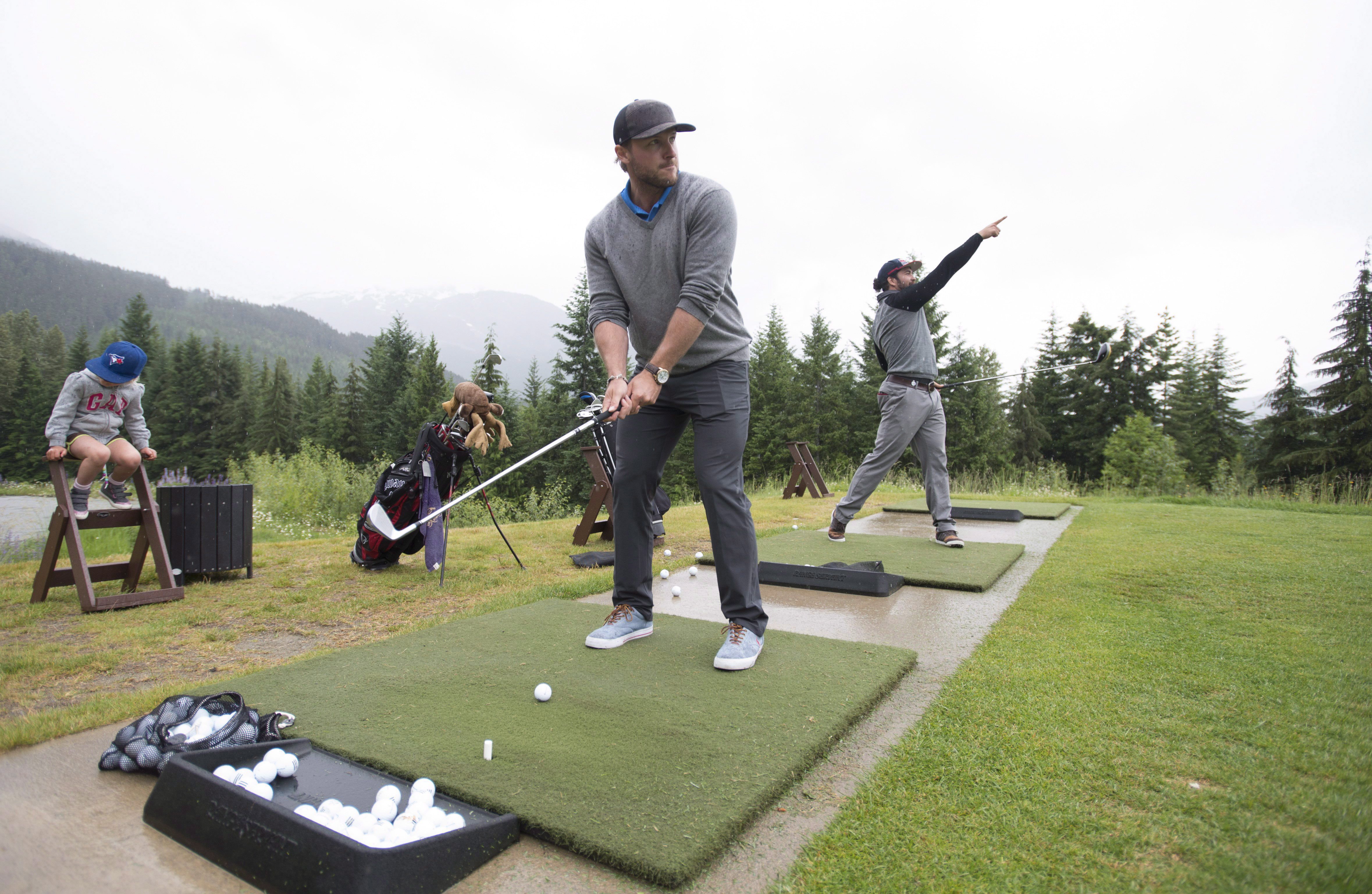 Bobsled athletes Chris Spring, right, and Justin Kripps hit shots at the Fairmont driving range in Whistler, B.C., Wednesday, June, 8, 2016. Spring and Kripps have taken up golf this summer as part of their training program, with a goal of sharpening focus and improving mental toughness. THE CANADIAN PRESS/Jonathan Hayward