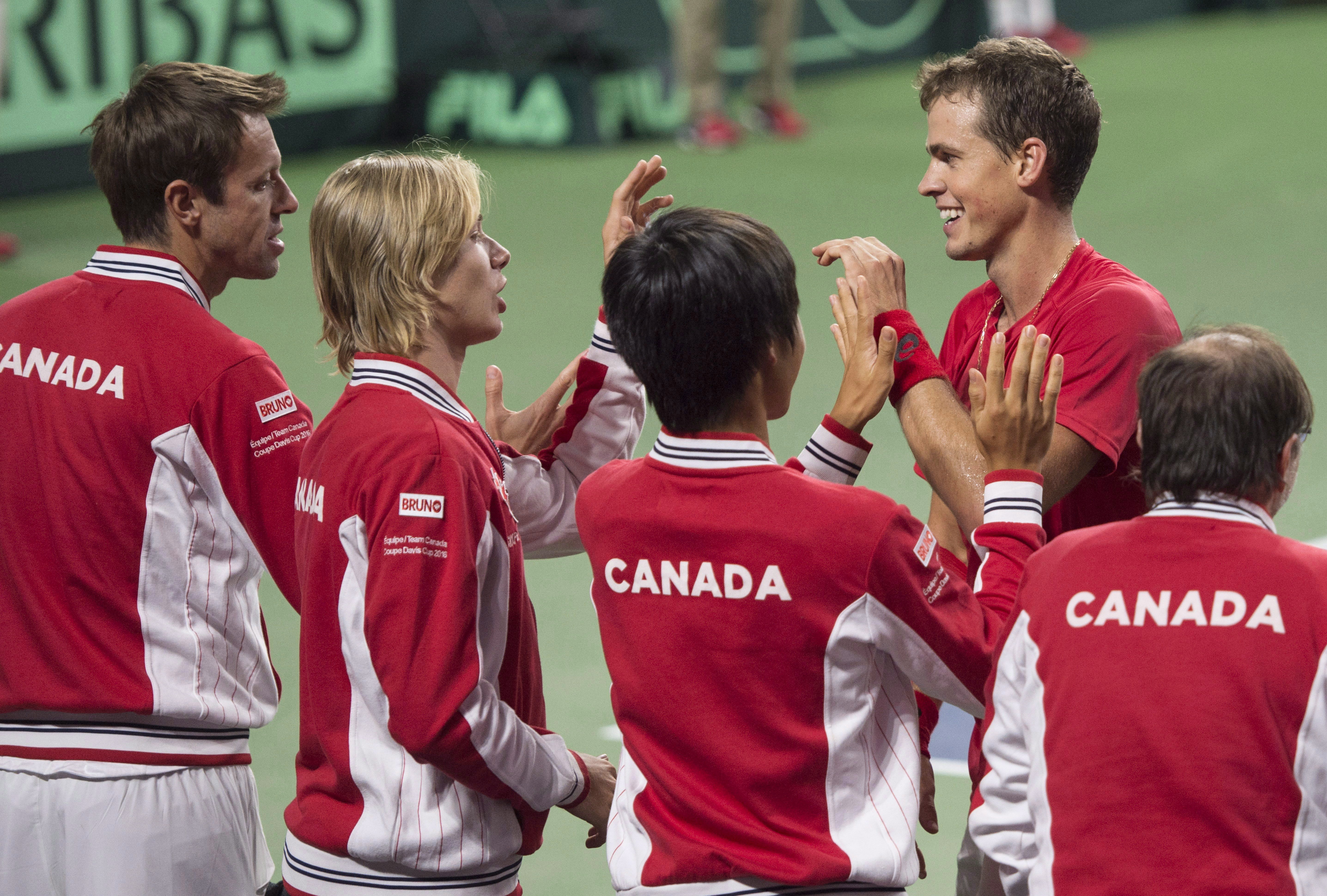 Canada's Vasek Pospisil, second from right, celebrates with teammates after defeating Chile's Nicolas Jarry in Davis Cup tennis World Group playoff singles action in Halifax on Friday, September 16, 2016. THE CANADIAN PRESS/Darren Calabrese