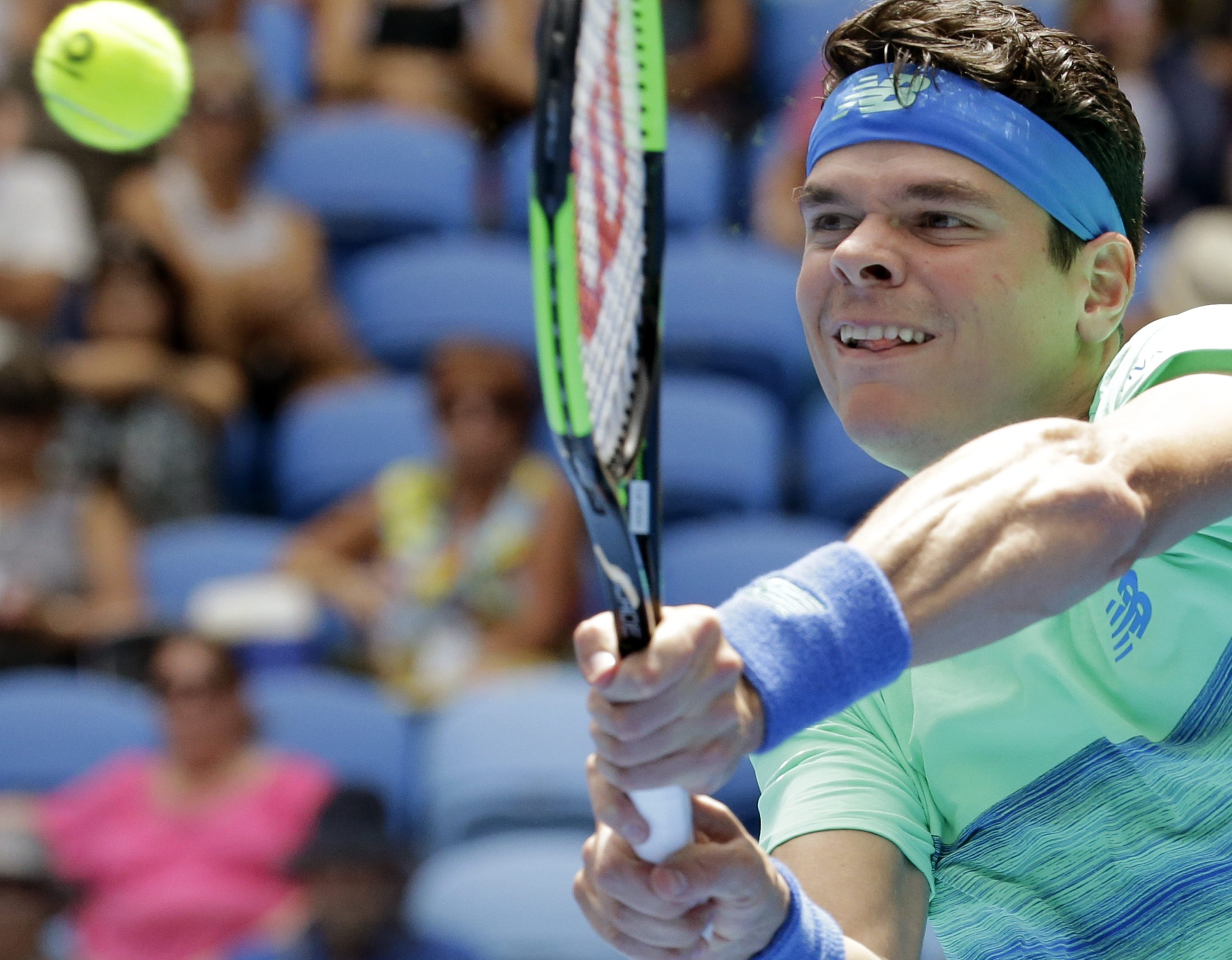 Canada's Milos Raonic makes a backhand return to Germany's Dustin Brown during their first round match at the Australian Open tennis championships in Melbourne, Australia, Tuesday, Jan. 17, 2017. (AP Photo/Aaron Favila)