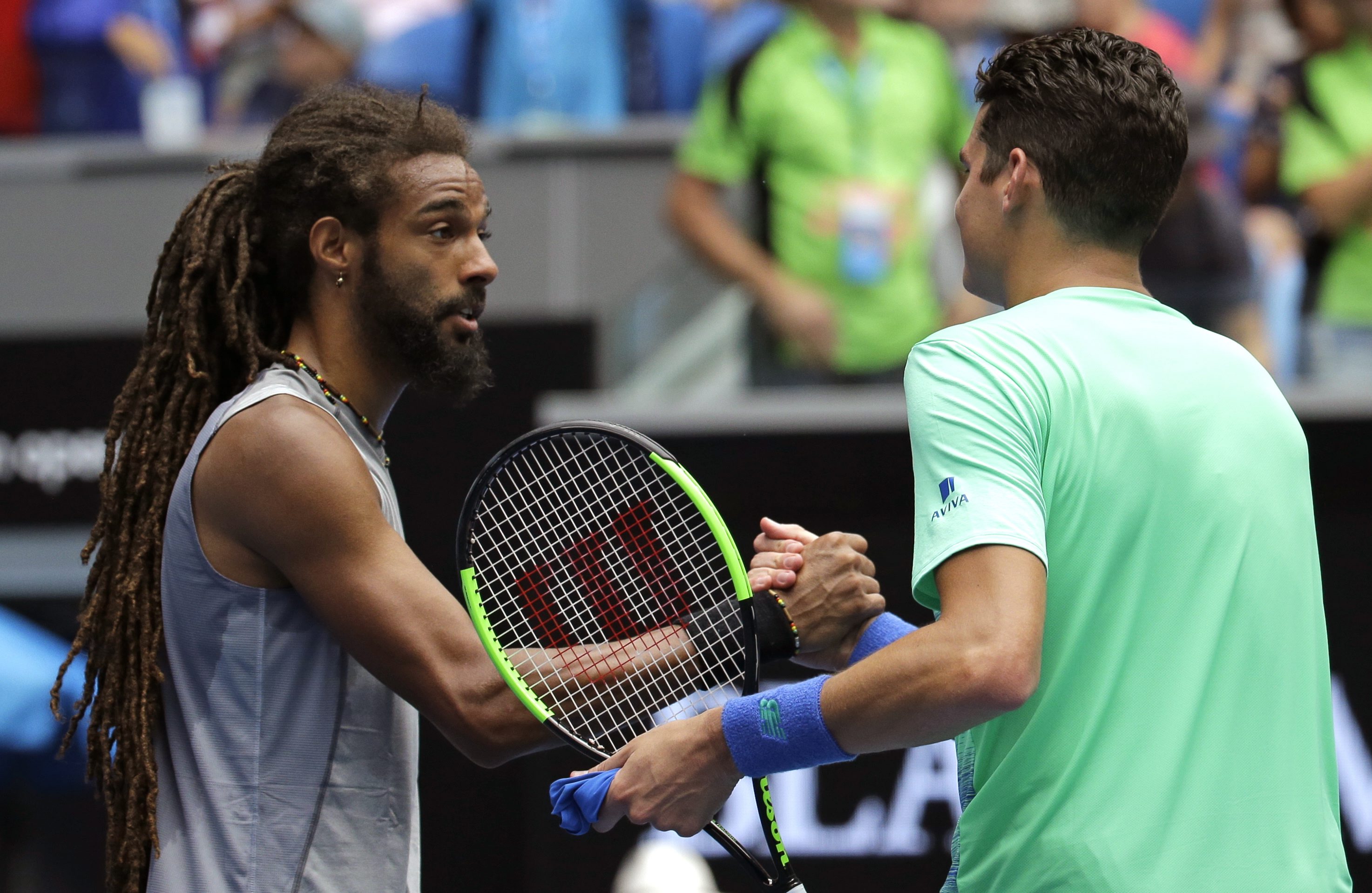 Canada's Milos Raonic, right, is congratulated by Germany's Dustin Brown following their first round match at the Australian Open tennis championships in Melbourne, Australia, Tuesday, Jan. 17, 2017. (AP Photo/Aaron Favila)