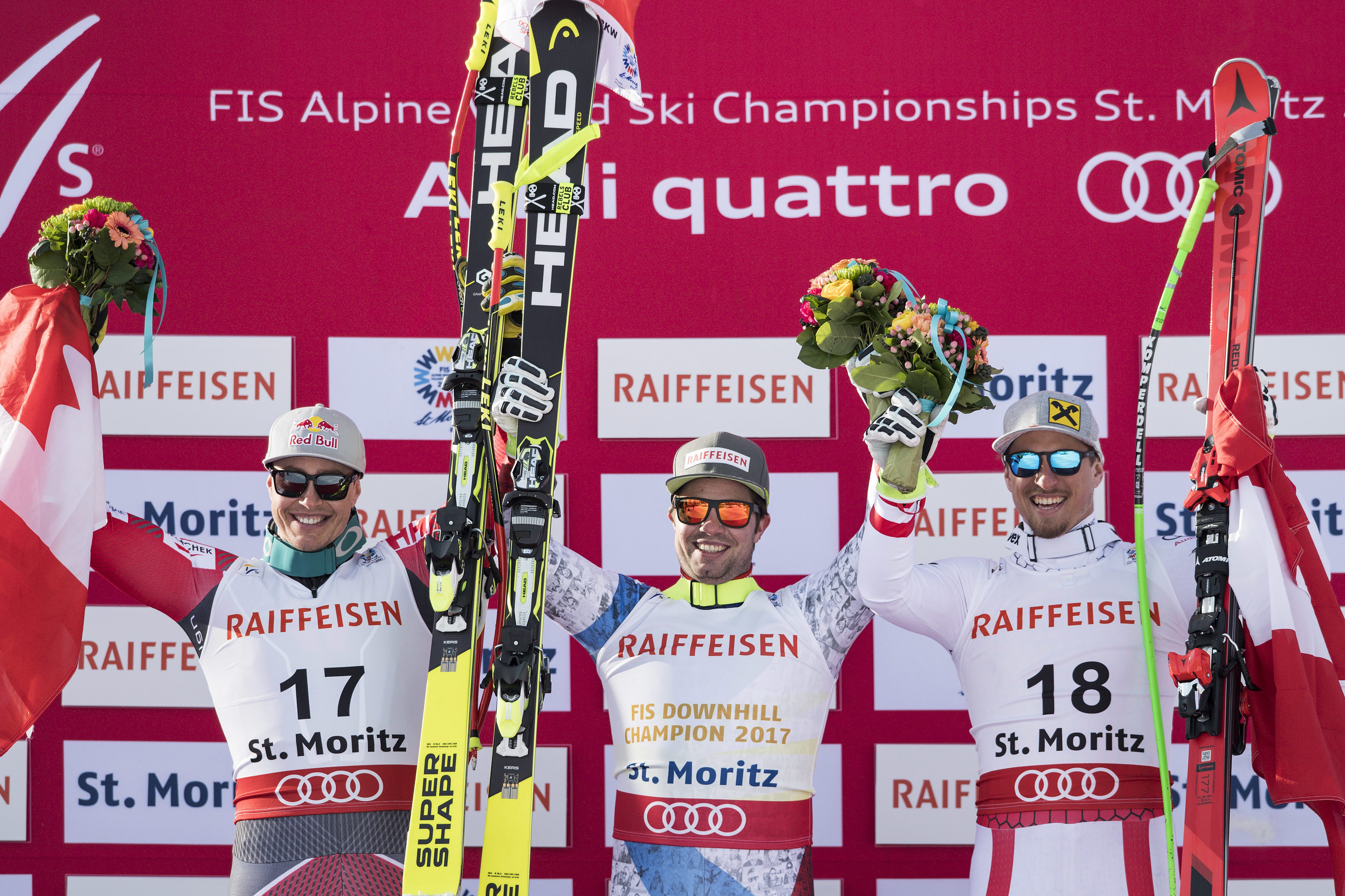 Erik Guay of Canada, second placed, Beat Feuz of Switzerland, winner, and Max Franz of Austria, third place, celebrate during the men downhill winner presentation at the 2017 FIS Alpine Skiing World Championships in St. Moritz, Switzerland, Sunday, Feb. 12, 2017. (Peter Schneider/Keystone via AP)