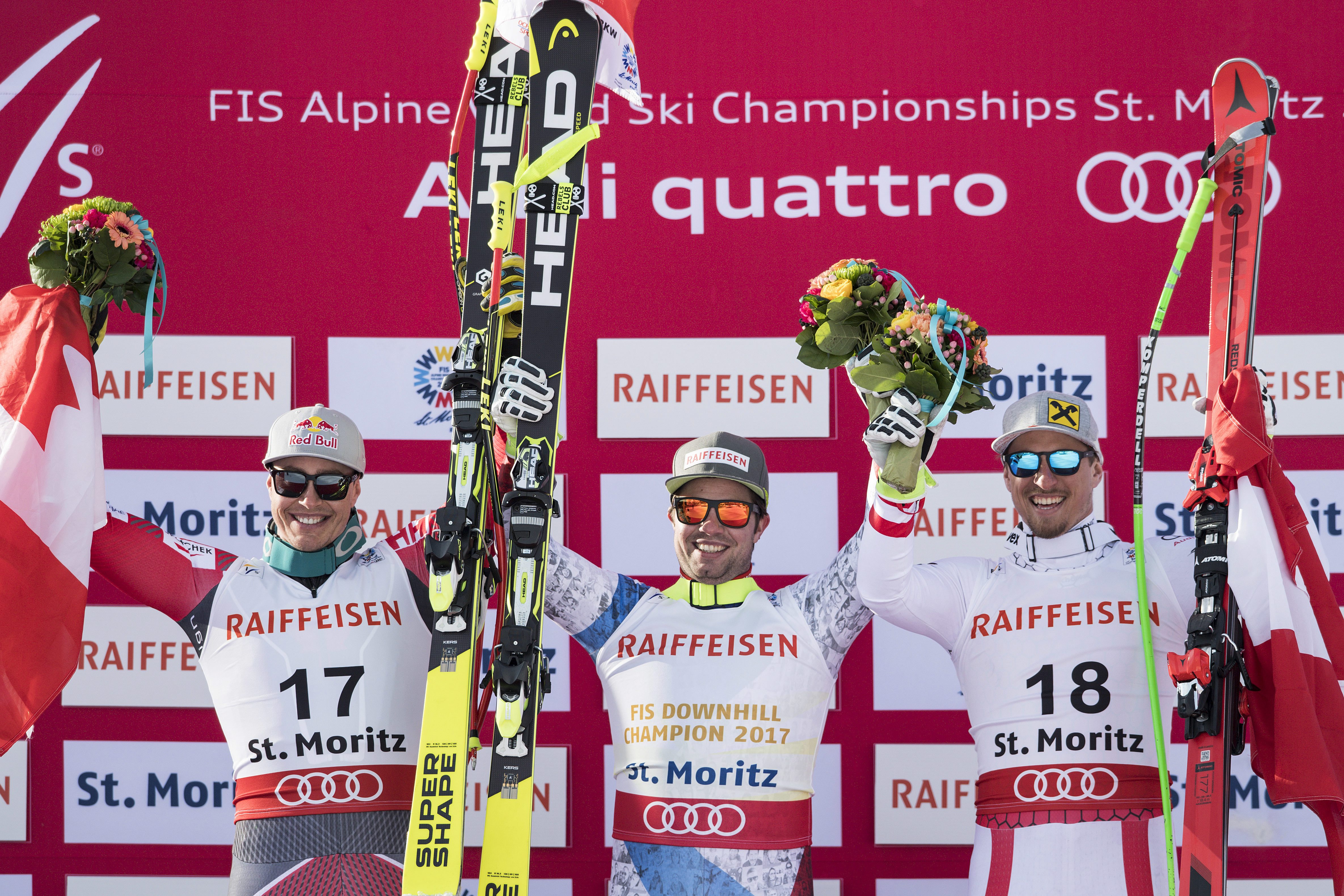 Erik Guay of Canada, second placed, Beat Feuz of Switzerland, winner, and Max Franz of Austria, third place,  celebrate during the men downhill winner presentation at the 2017 FIS Alpine Skiing World Championships in St. Moritz, Switzerland, Sunday, Feb. 12, 2017. (Peter Schneider/Keystone via AP)