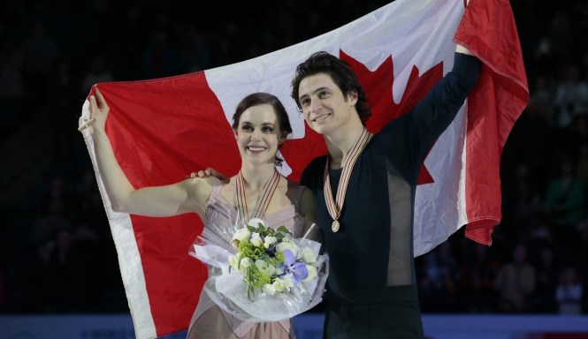 Tessa Virtue and Scott Moir, of Canada, pose with their gold medals and the national flag during victory ceremony at the World figure skating championships in Helsinki, Finland, on Saturday, April 1, 2017. (AP Photo/Ivan Sekretarev)