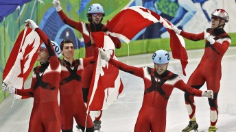 Short track speed skaters carry Canadian flag
