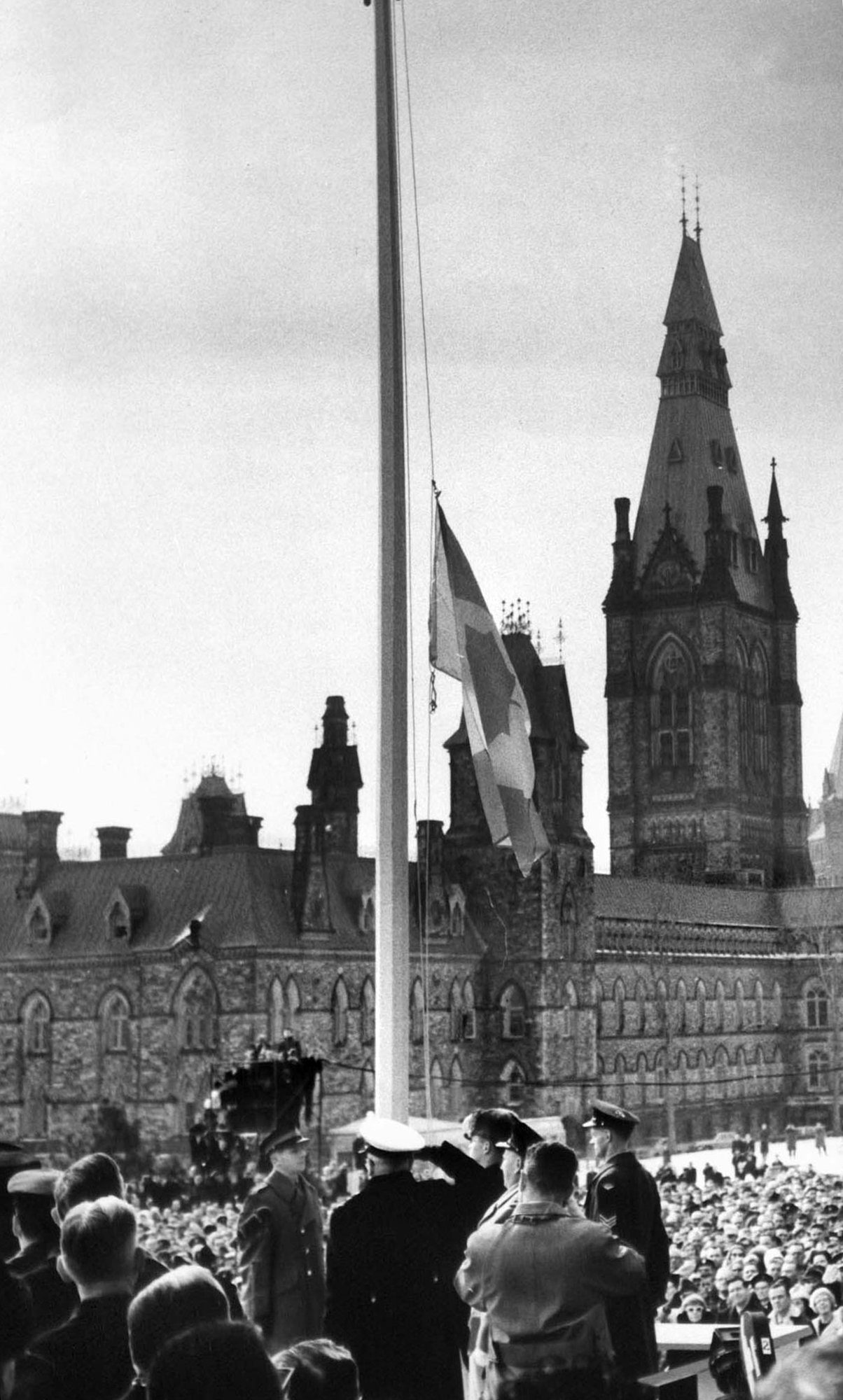 RCMP Constable Joseph Secours raises Canada's Maple Leaf flag on the flagpole at base of Peace Tower on Parliament Hill in Ottawa February 15, 1965. (CP Photo)