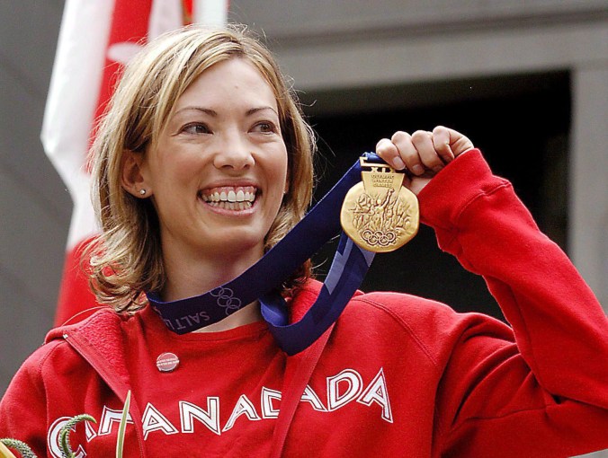 Canadian cross-country skier Beckie Scott displays her gold medal she was awarded at a ceremony in Vancouver, Friday, June 25, 2004. THE CANADIAN PRESS/Chris Bolin