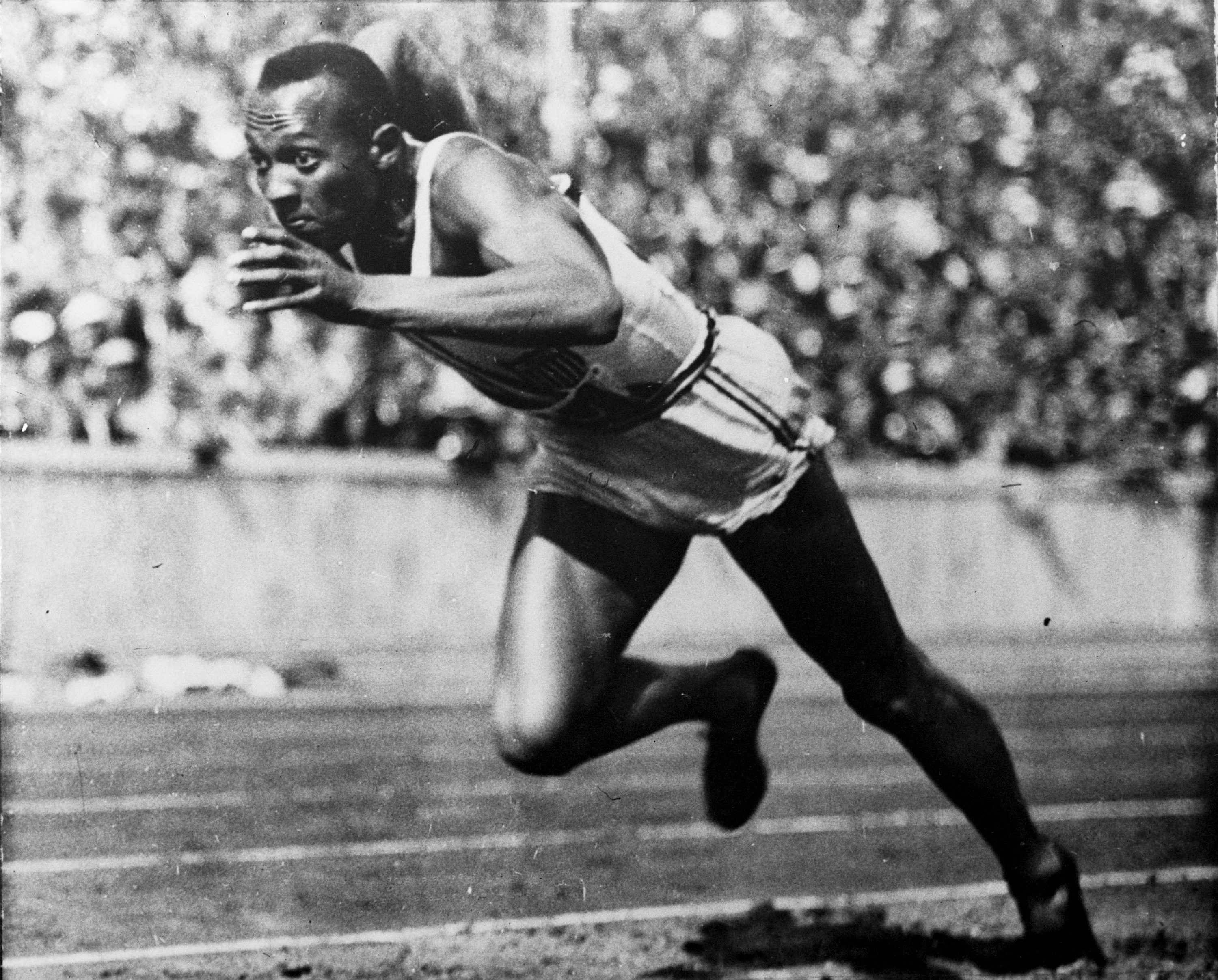 FILE - This 1936 file photo shows Jesse Owens in action in a 200-meter preliminary heat at the 1936 Summer Olympic Games in Berlin. Hop on the Underground at "Jesse Owens" station. After one stop change at "Carl Lewis." And then ride the Tube all the way to "Michael Phelps." That, sports fans, will get you from central London right to the Olympic Stadium. (AP Photo/File)