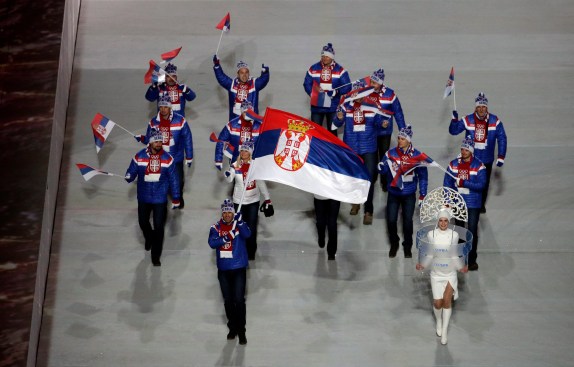 Milanko Petrovic of Serbia holds his national flag and enters the arena with teammates during the opening ceremony of the 2014 Olympic Winter Games in Sochi, Russia, Friday, Feb. 7, 2014. (AP Photo/Charlie Riedel)