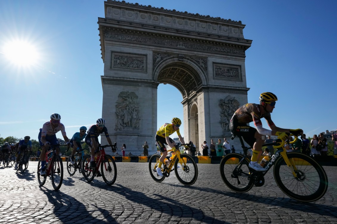 Cyclists go past the Arc de Triiomphe during a road race
