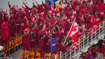 Team Canada athletes all dressed in red on the top deck of a boat during the Paris 2024 Opening Ceremony