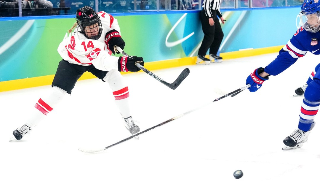 Renata Fast in white jersey just after shooting puck