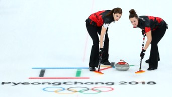 Lisa Weagle and Joanne Courtney sweep a stone down the ice
